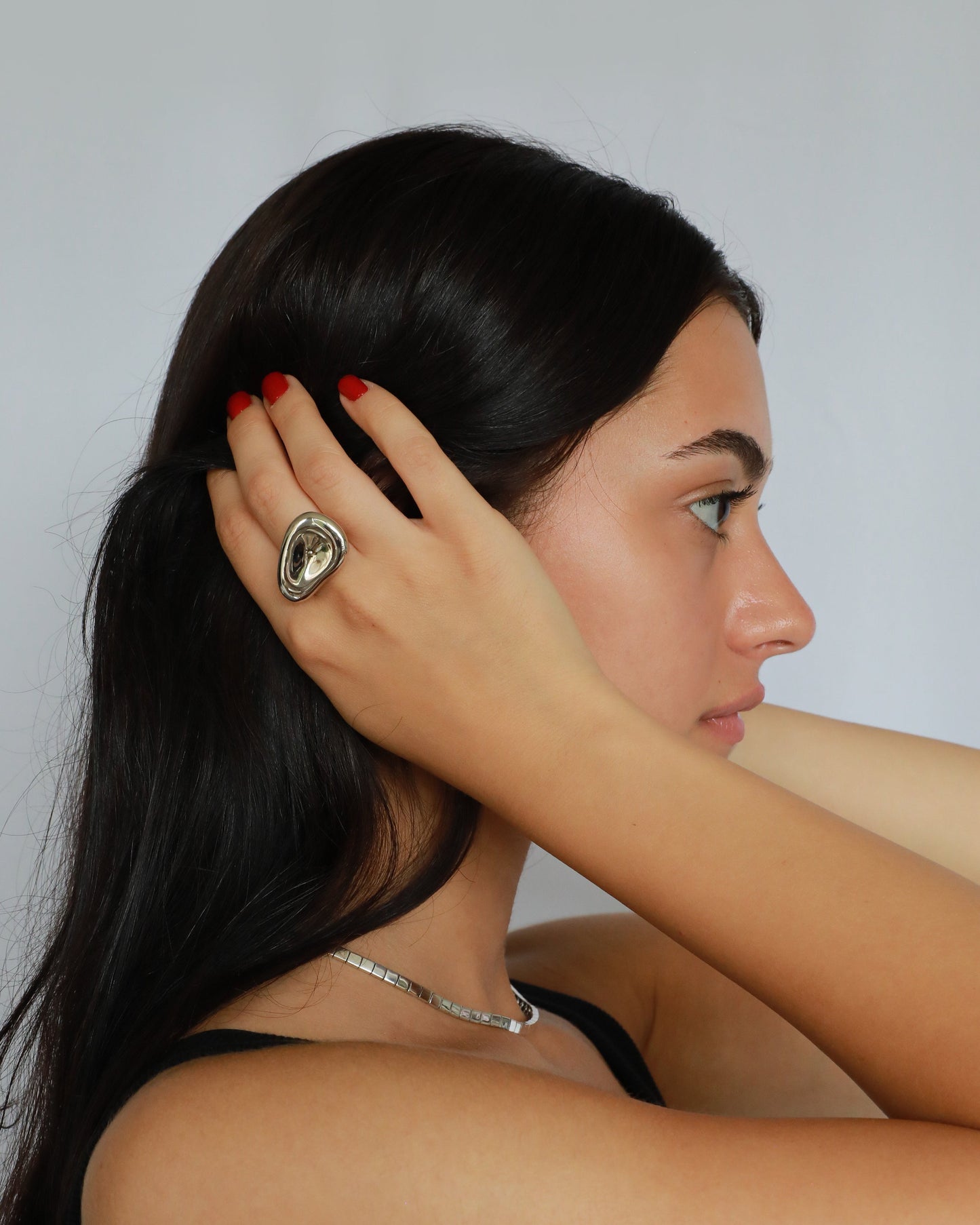 Sterling silver statement ring worn by female model, showcasing unisex molten design on hand