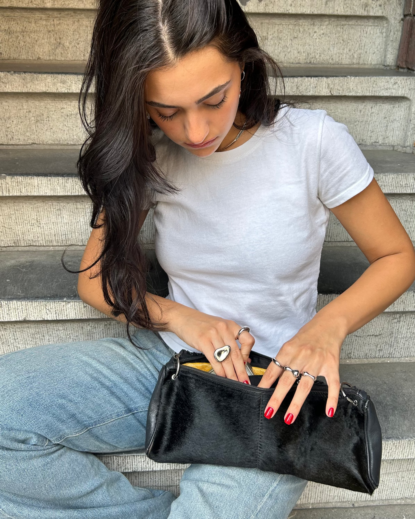 Street-style overhead shot of adjustable silver dome ring with red nails and denim outfit