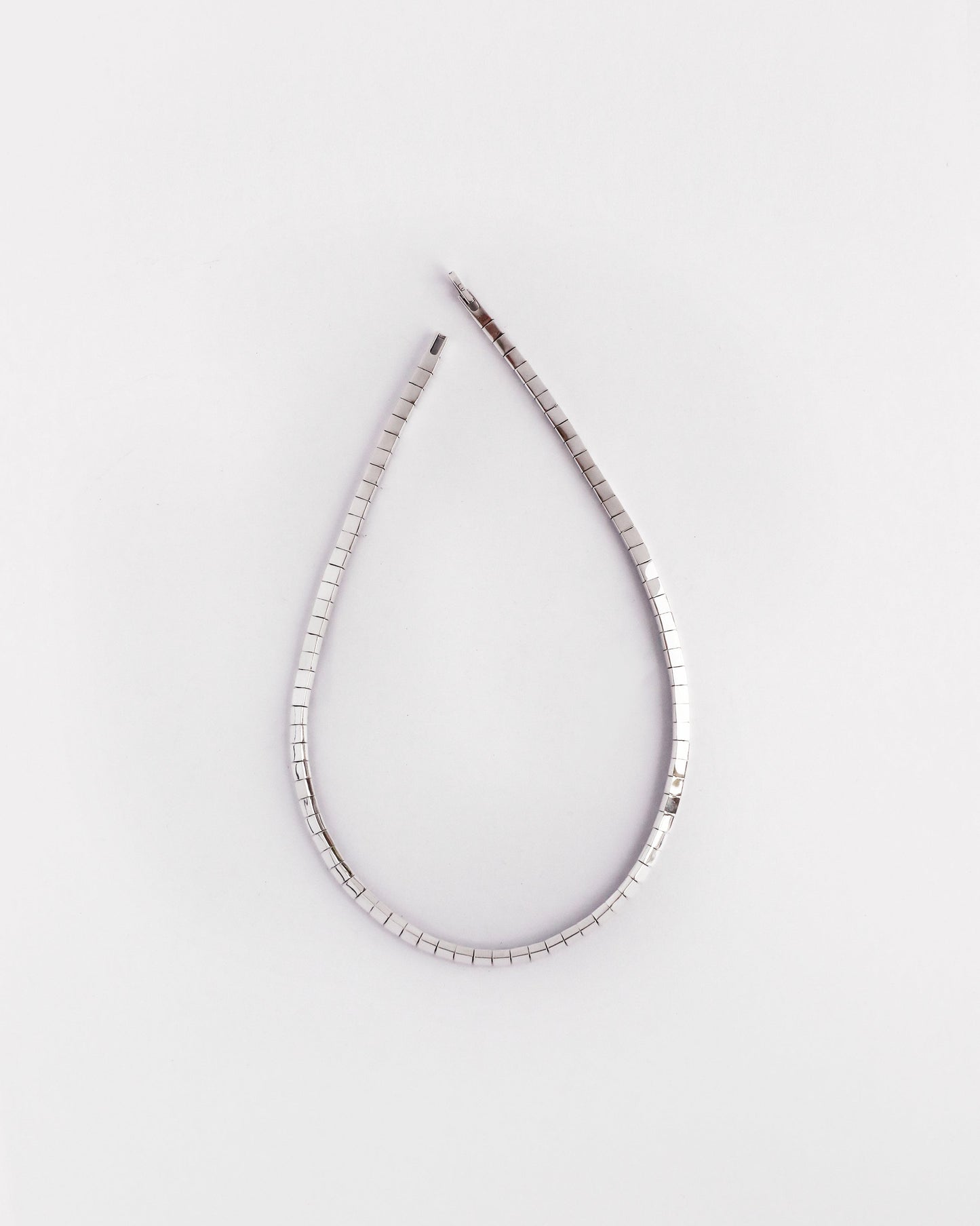 Solid silver flexible necklace in minimalist teardrop shape with reflective finish