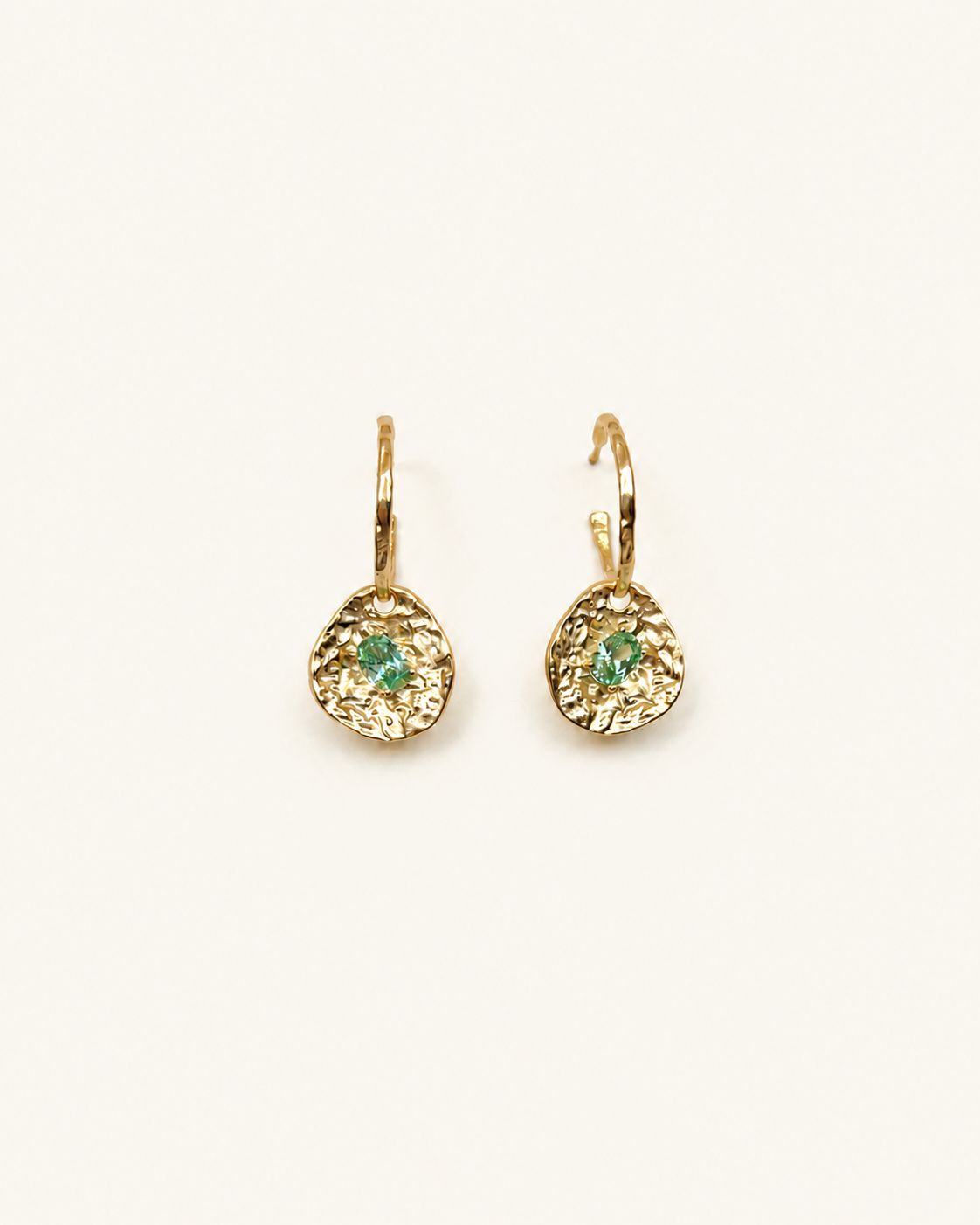 Gold coin drop earrings with hammered 18K gold-plated brass pendants and two round green beryl CZ stones on a white background.