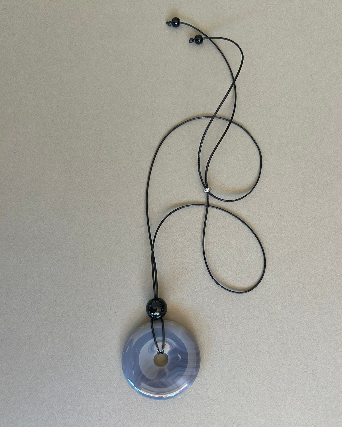 Necklace with a round pendant on a light gray background