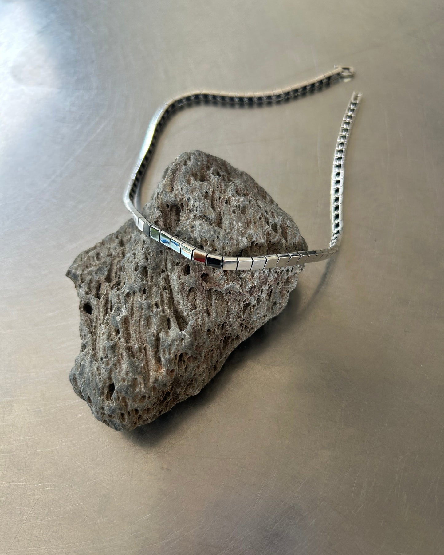 Sterling silver box link necklace displayed on lava rock surface