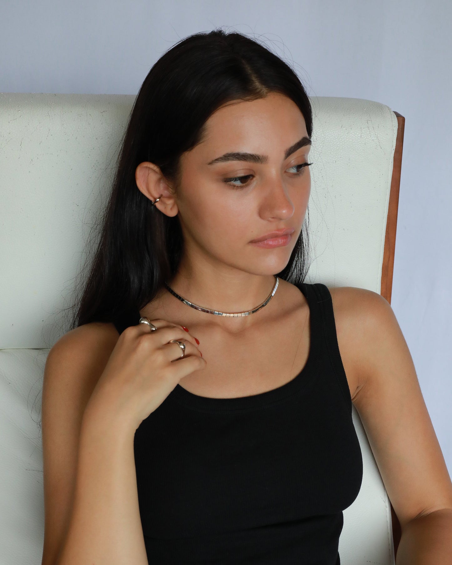 Female model wearing minimalist sterling silver chain necklace in seated pose