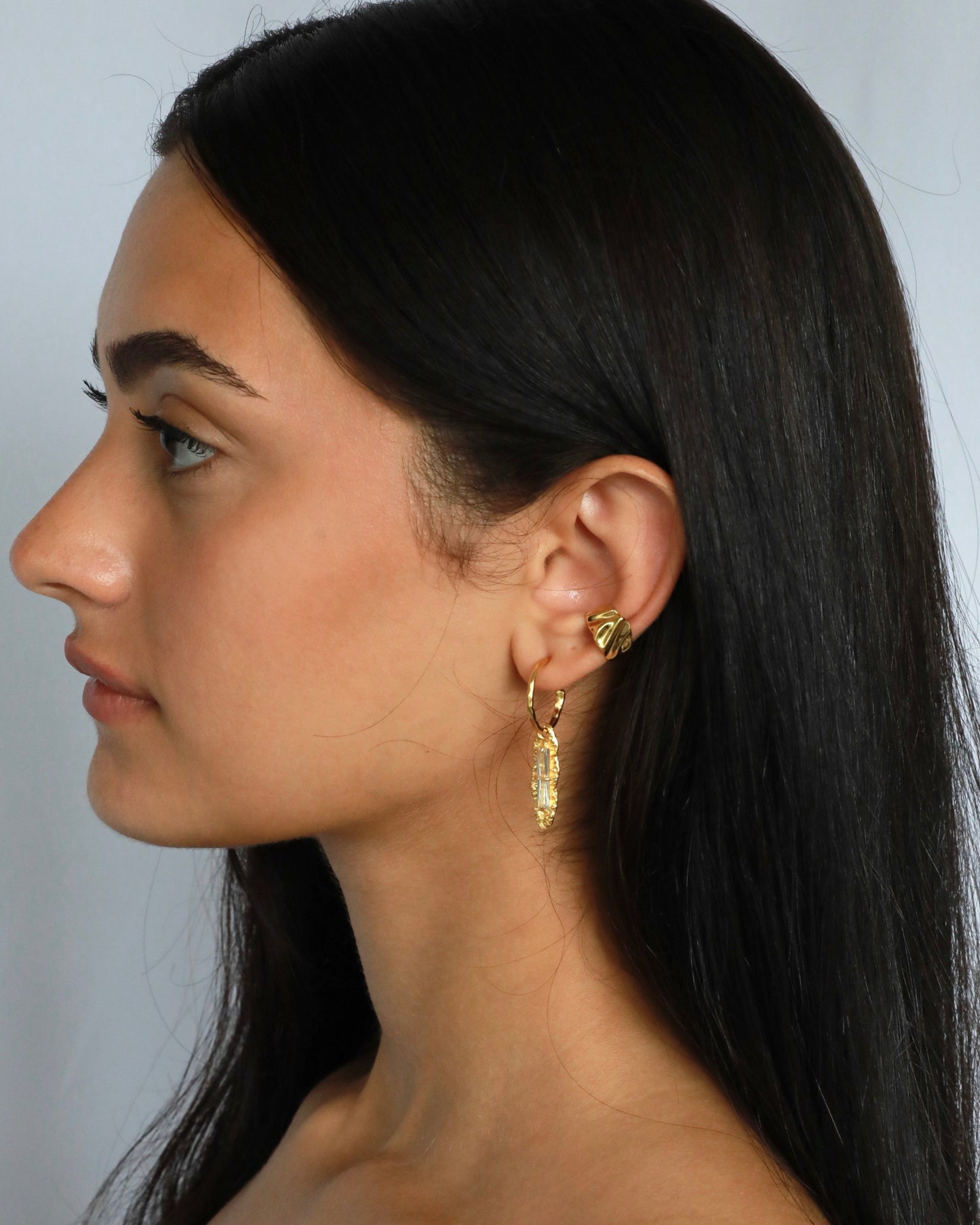 Close-up of sculpted 18K gold ear cuff with textured finish, designed for non-pierced ears