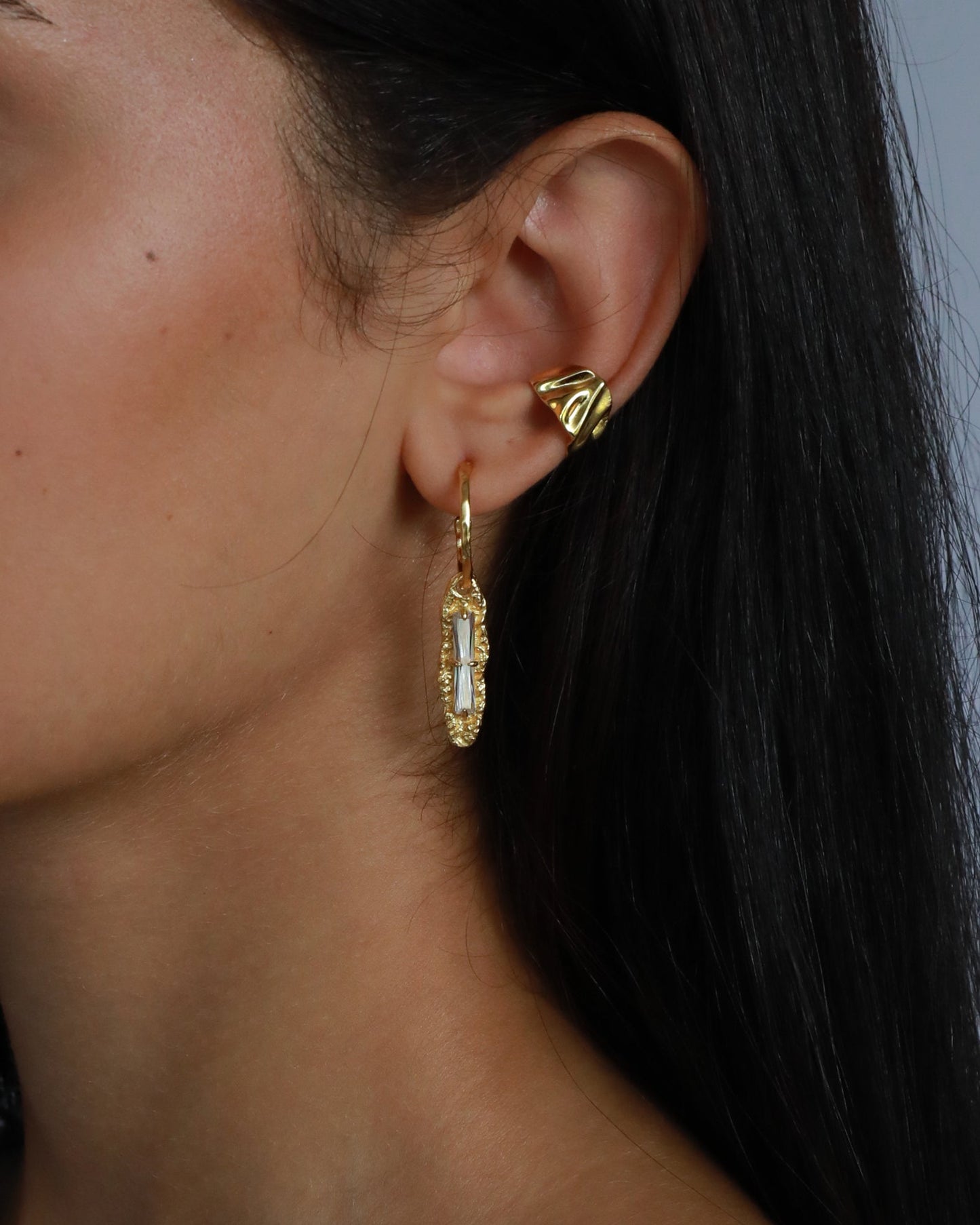 Close-up of sculpted 18K gold ear cuff with textured finish, designed for non-pierced ears