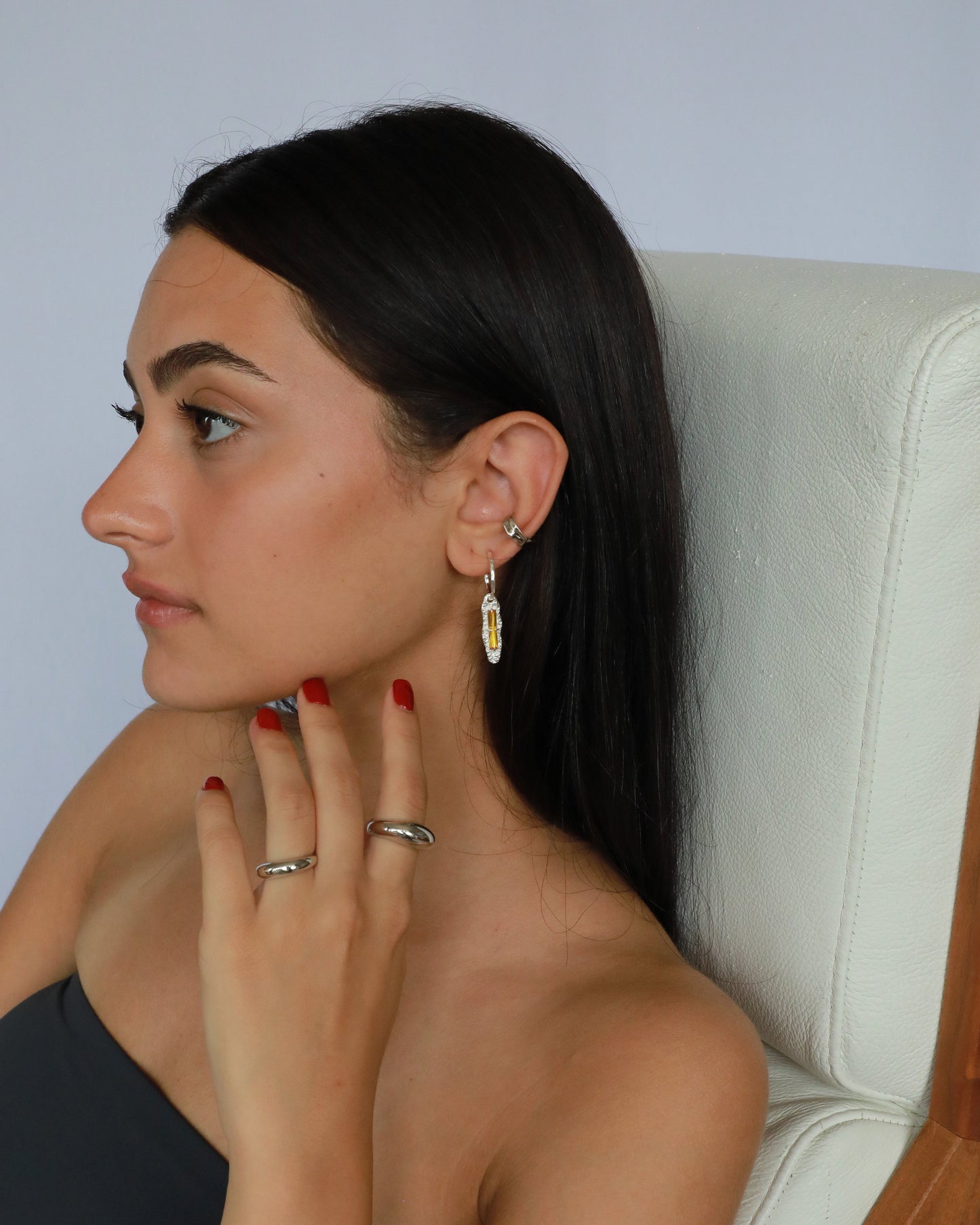 Model wearing silver sculpted ear cuff paired with silver hoop and rings, perfect stacked jewelry look