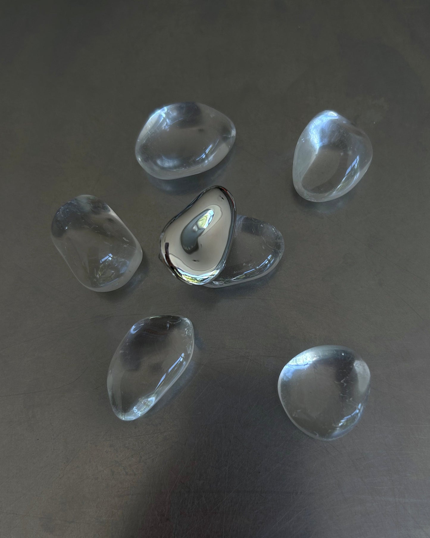Sterling silver molten ring styled flat with glass-like stones on metal surface