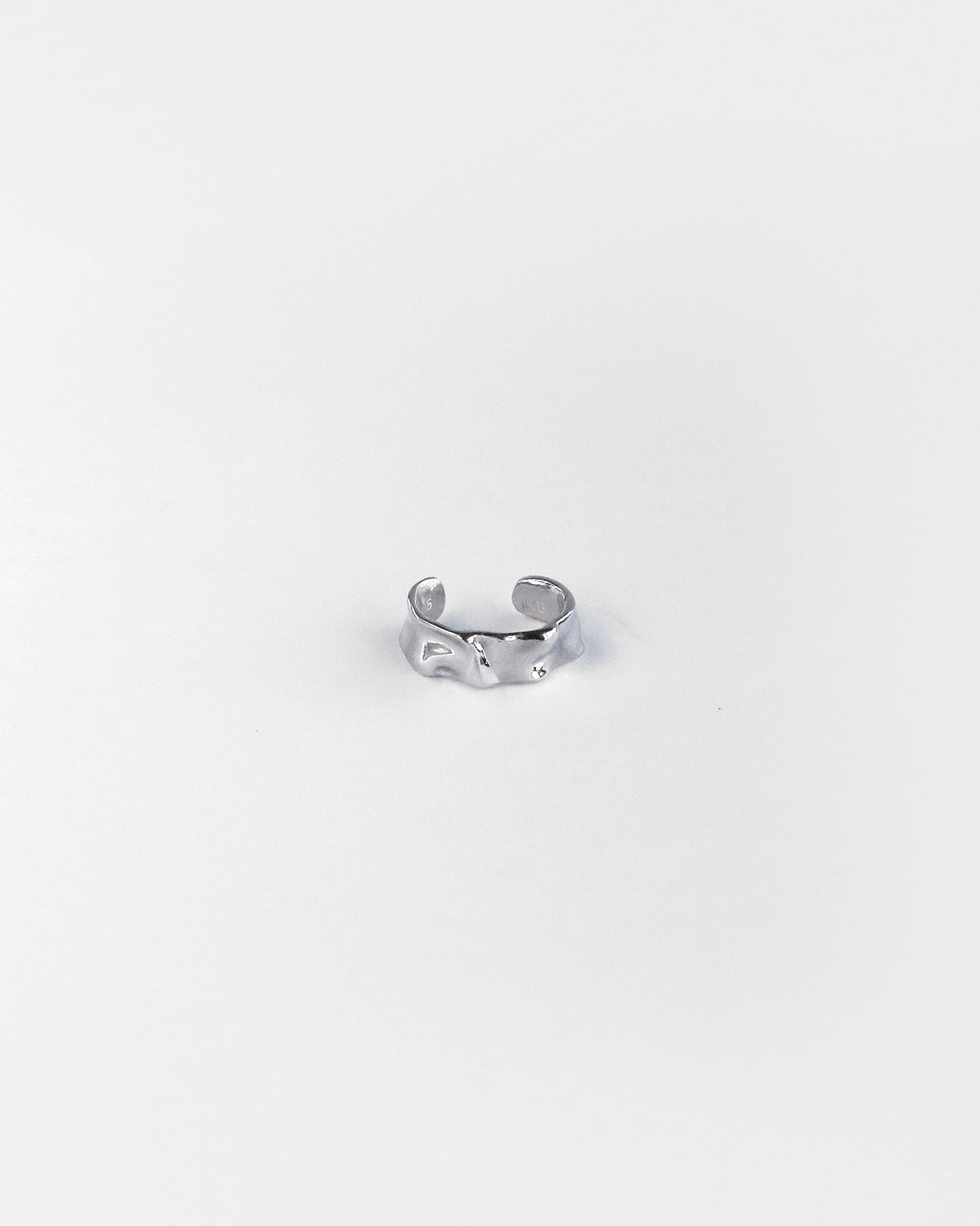 Close-up of sculpted silver ear cuff with textured finish, designed for non-pierced ears