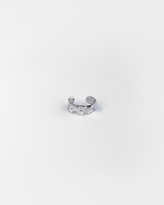 Close-up of sculpted silver ear cuff with textured finish, designed for non-pierced ears