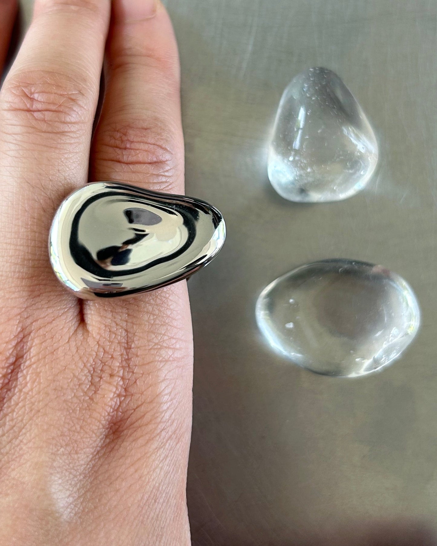 Sculptural sterling silver ring with mirror finish worn on hand, unisex adjustable fit