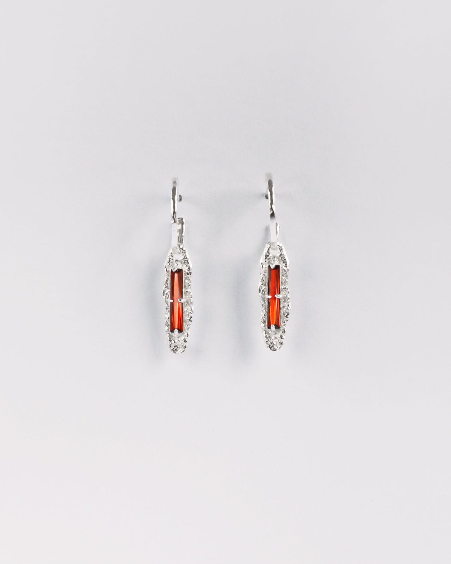 Sterling silver earrings with red cubic zirconia on white background