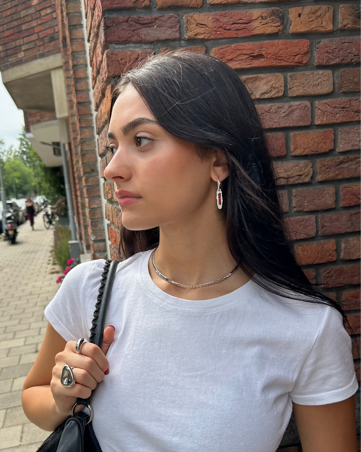 Model wearing handcrafted sterling silver earrings with red zircon