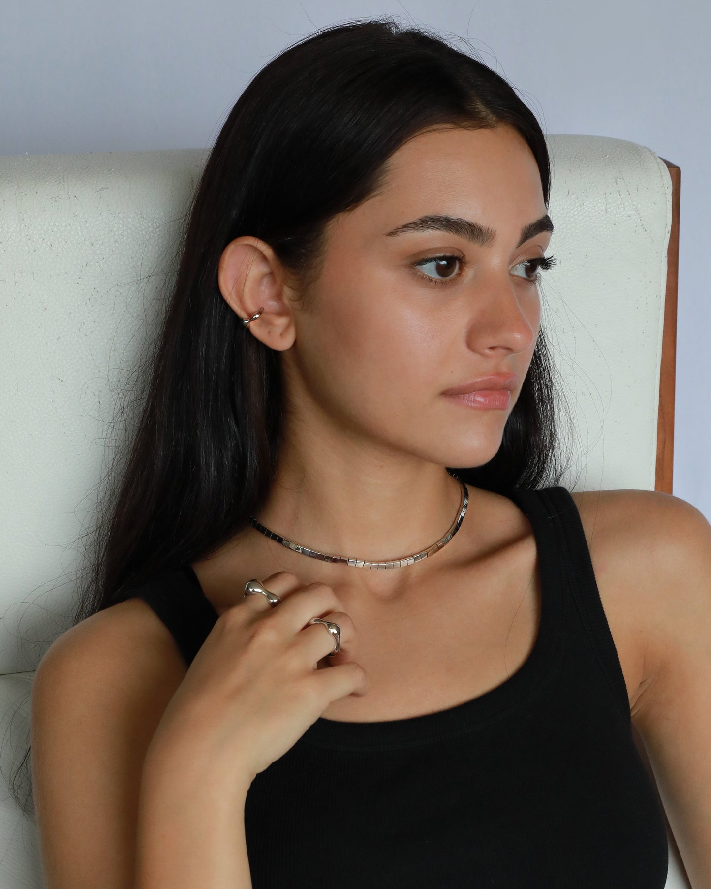 Sculptural silver necklace worn by model in everyday styling, wide angle