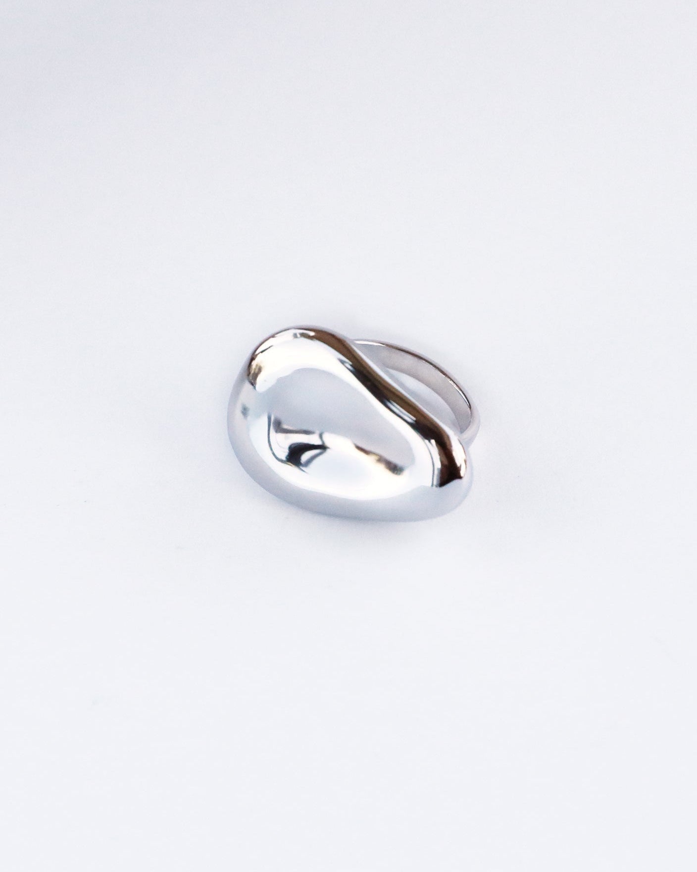Minimalist studio shot of dome-shaped sculptural silver ring with smooth high-gloss finish