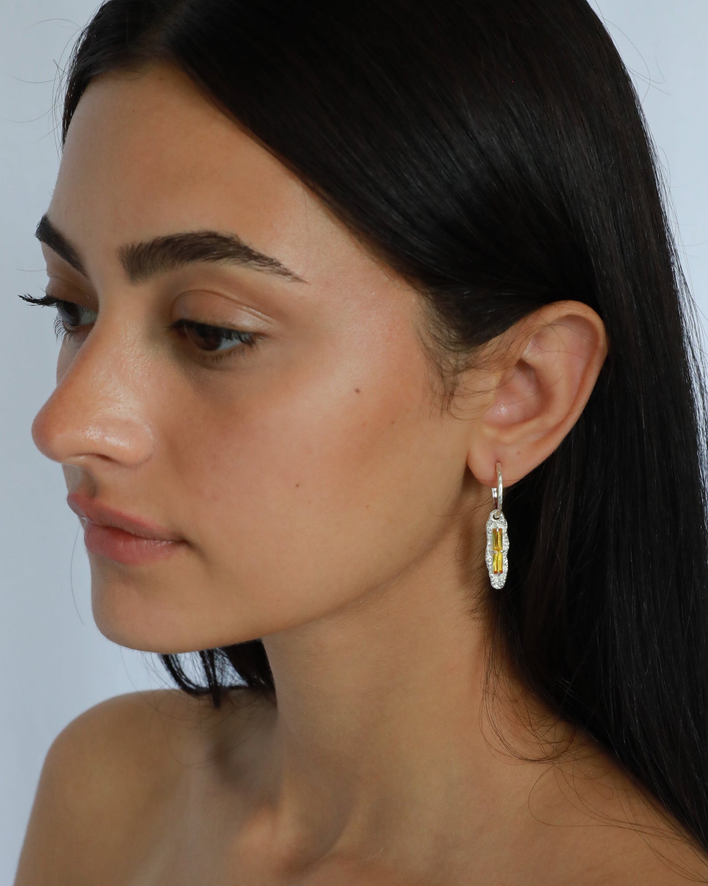 Model wearing yellow zircon sterling silver earrings, side profile showing gemstone sparkle