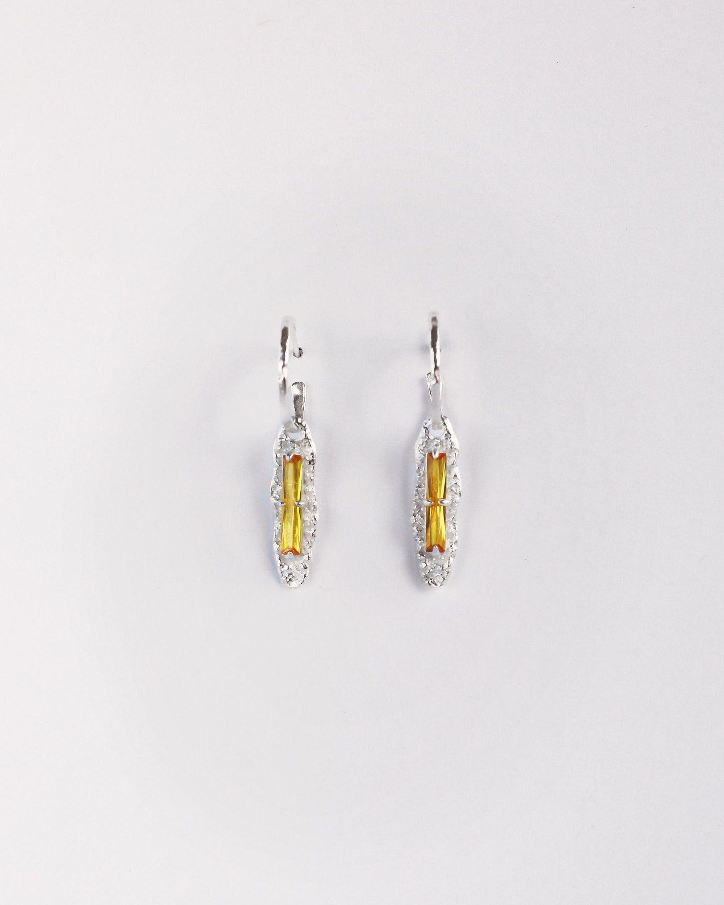 Front view of yellow zircon sterling silver drop earrings on white background