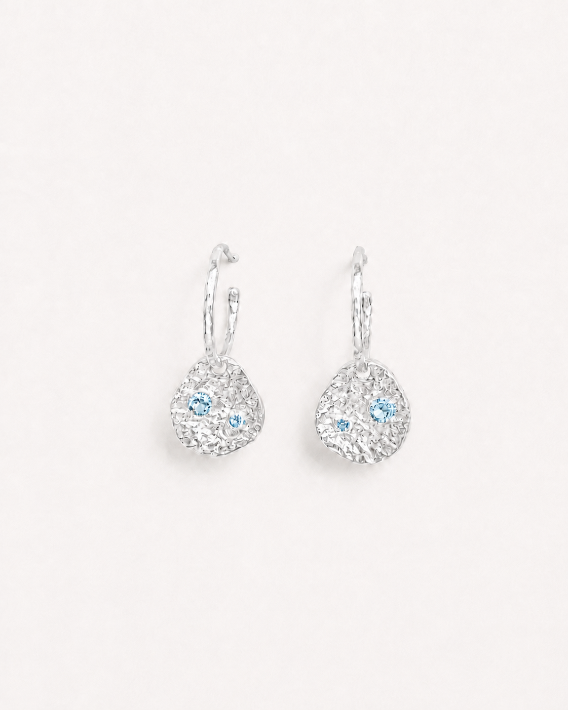 Silver coin drop earrings with hammered silver-plated brass pendants and two round lab-grown aquamarine-blue spinel stones.
