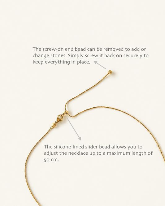 Instructional diagram showing a gold necklace with text callouts explaining how to remove the screw-on end bead and how the silicone-lined slider bead allows length adjustment, on a light cream background.