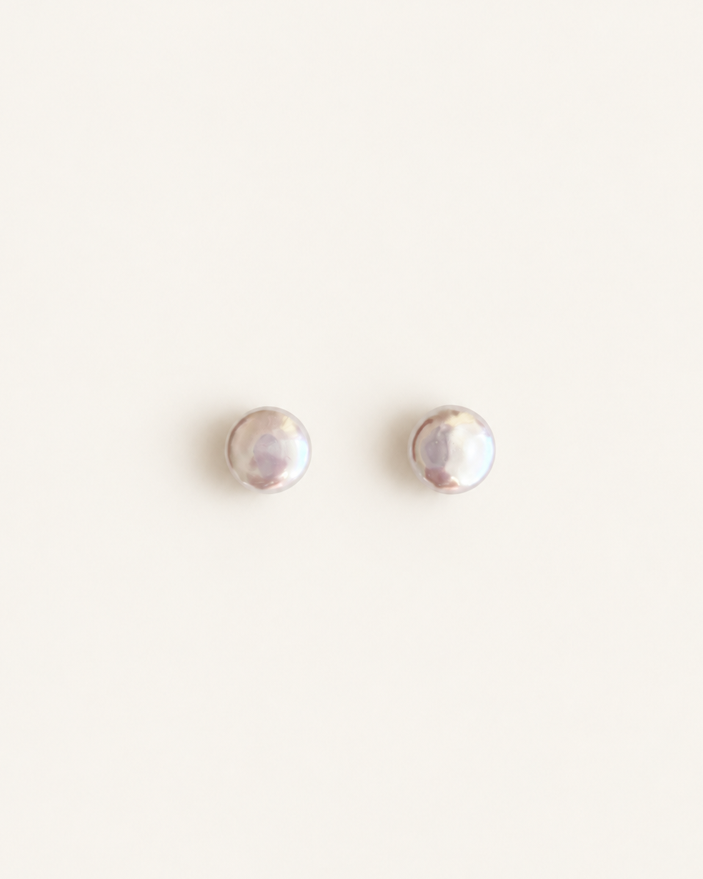 A pair of small round stud earrings with a pearlescent iridescent finish, displayed on a clean off-white background, made from natural pearls for wedding 