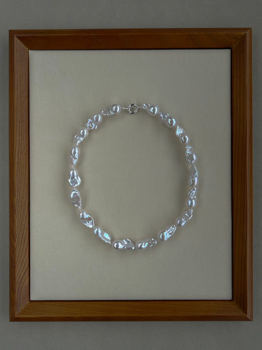 Framed baroque necklace on a neutral background