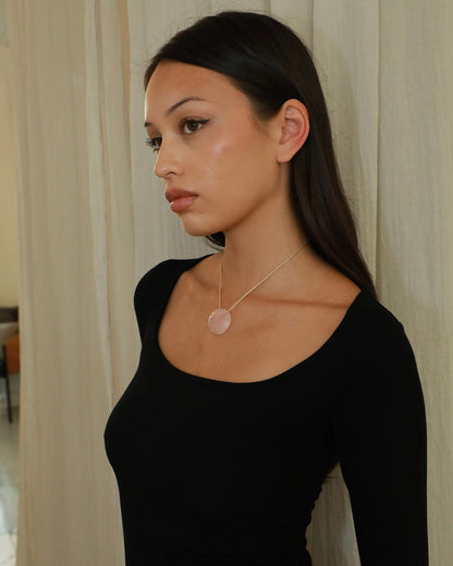 Adjustable beige cord necklace with an oval natural pink quartz pendant and black bead ends