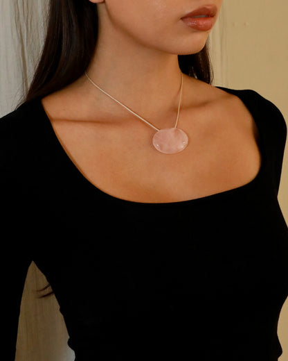 Adjustable beige cord necklace with an oval natural pink quartz pendant and black bead ends model