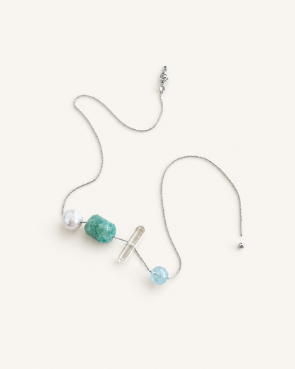 A delicate silver chain necklace with three distinct bead accents:Amazonite Clea rQuartz Aquamarine Freshwater pearls, displayed on a warm off-white background.