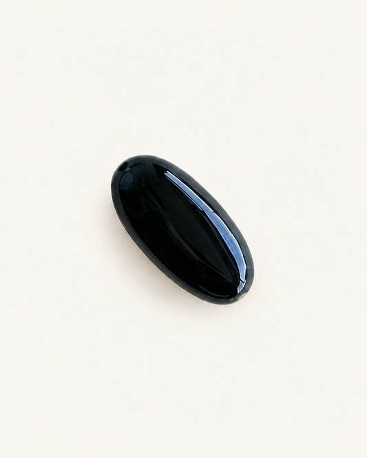 Mirror-polished black onyx cabochon with a single unbroken reflection