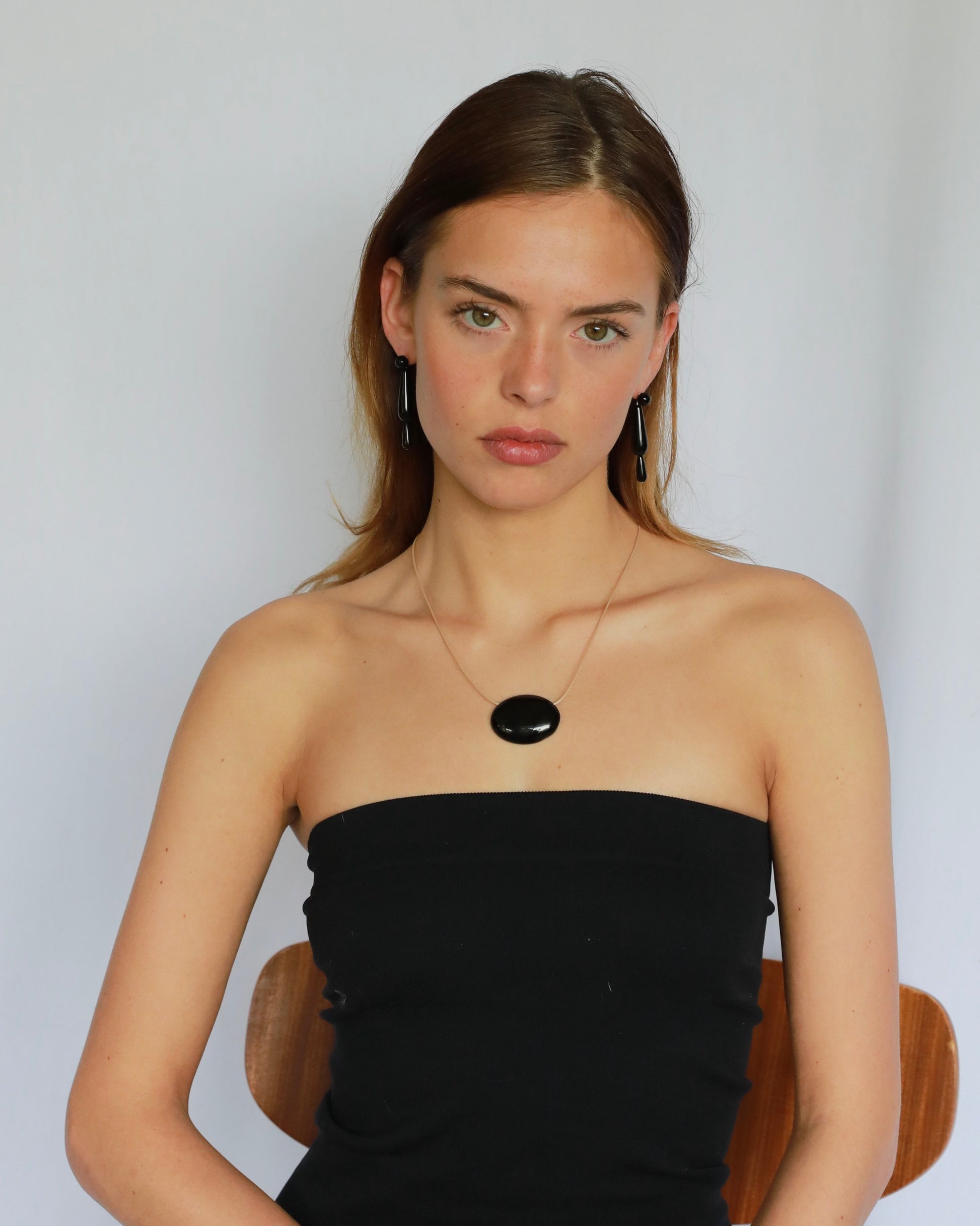 Super long adjustable necklace with polished natural black onyx pendant on soft beige cord. Minimal modern natural stone jewelry.