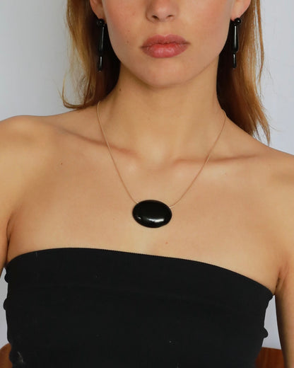 Super long adjustable necklace with polished natural black onyx pendant on soft beige cord. Minimal modern natural stone jewelry.