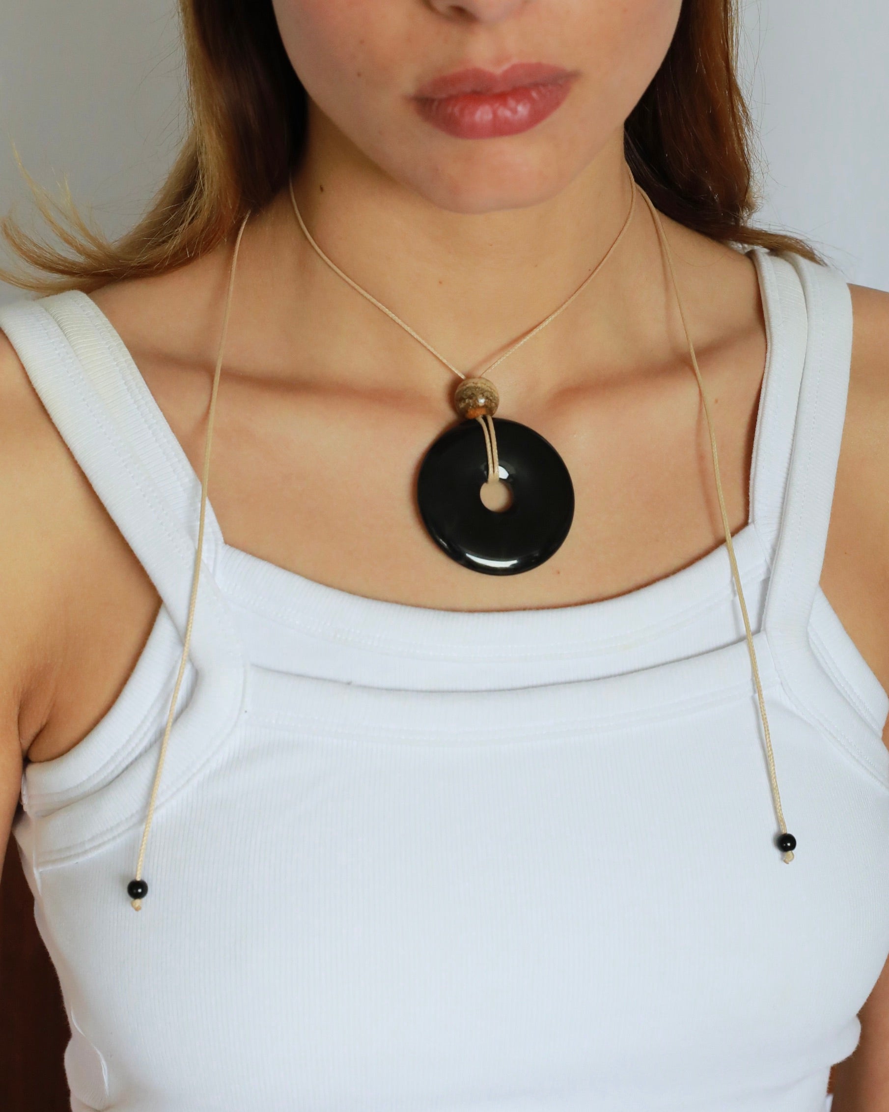 Super long adjustable necklace with polished black onyx pendant, natural picture jasper bead, and beige wax rope cord.