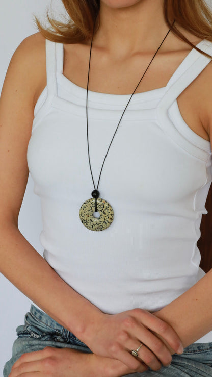 Super long dalmatian jasper pendant necklace with natural black and white spotted stone on adjustable black wax rope cord.