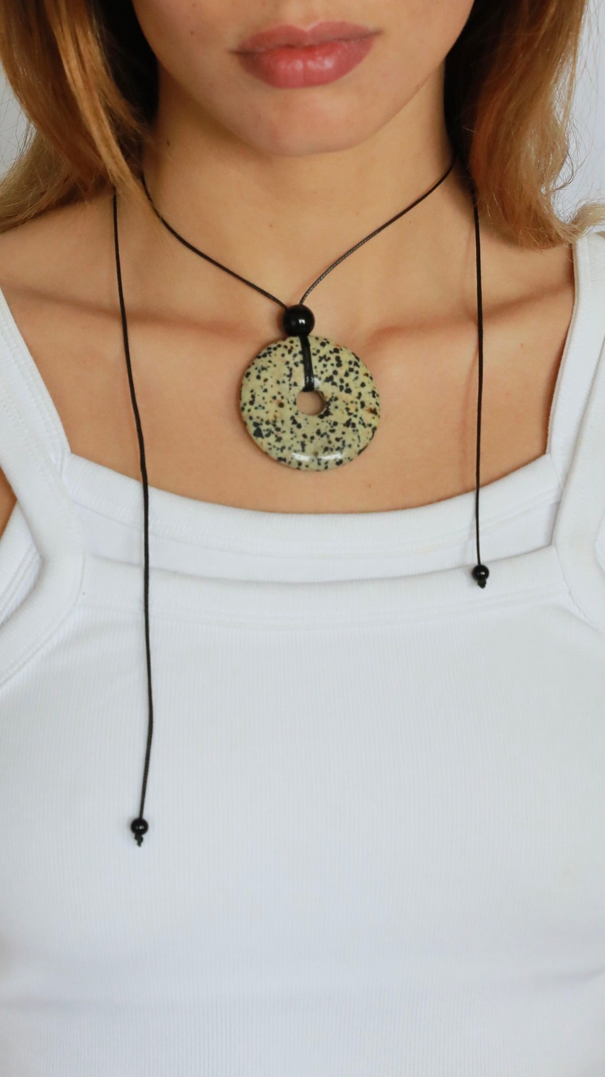 Super long dalmatian jasper pendant necklace with natural black and white spotted stone on adjustable black wax rope cord.