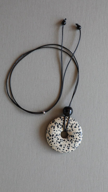 Super long dalmatian jasper pendant necklace with natural black and white spotted stone on adjustable black wax rope cord.