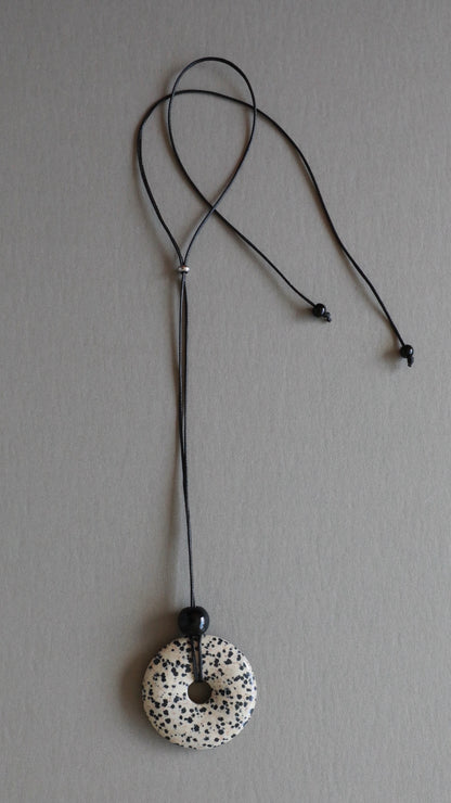 Super long dalmatian jasper pendant necklace with natural black and white spotted stone on adjustable black wax rope cord.