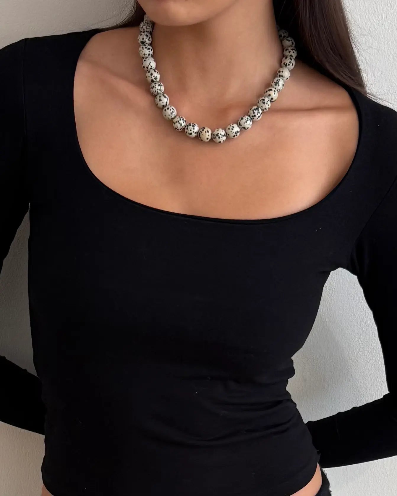 Chunky Dalmatian stone bead necklace with adjustable silver clasp in Nordic minimalist style close up on model