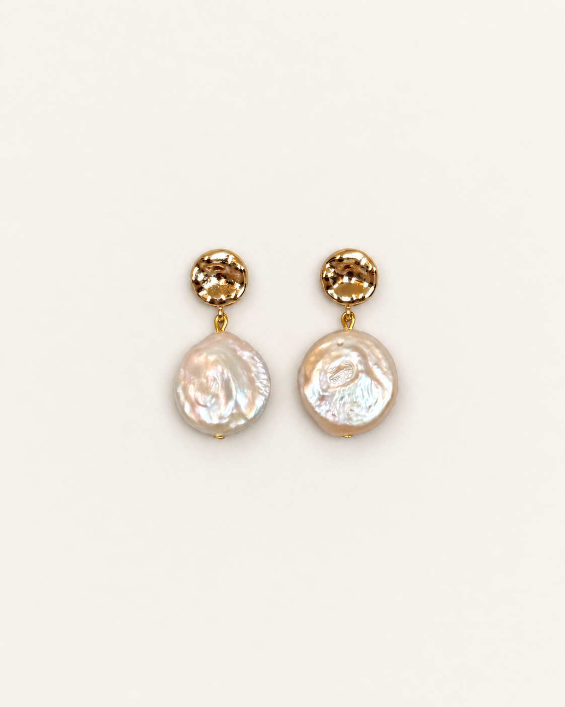 A pair of gold drop earrings featuring a faceted round gold top and a hanging irregular baroque pearl, shown on a plain off-white background.