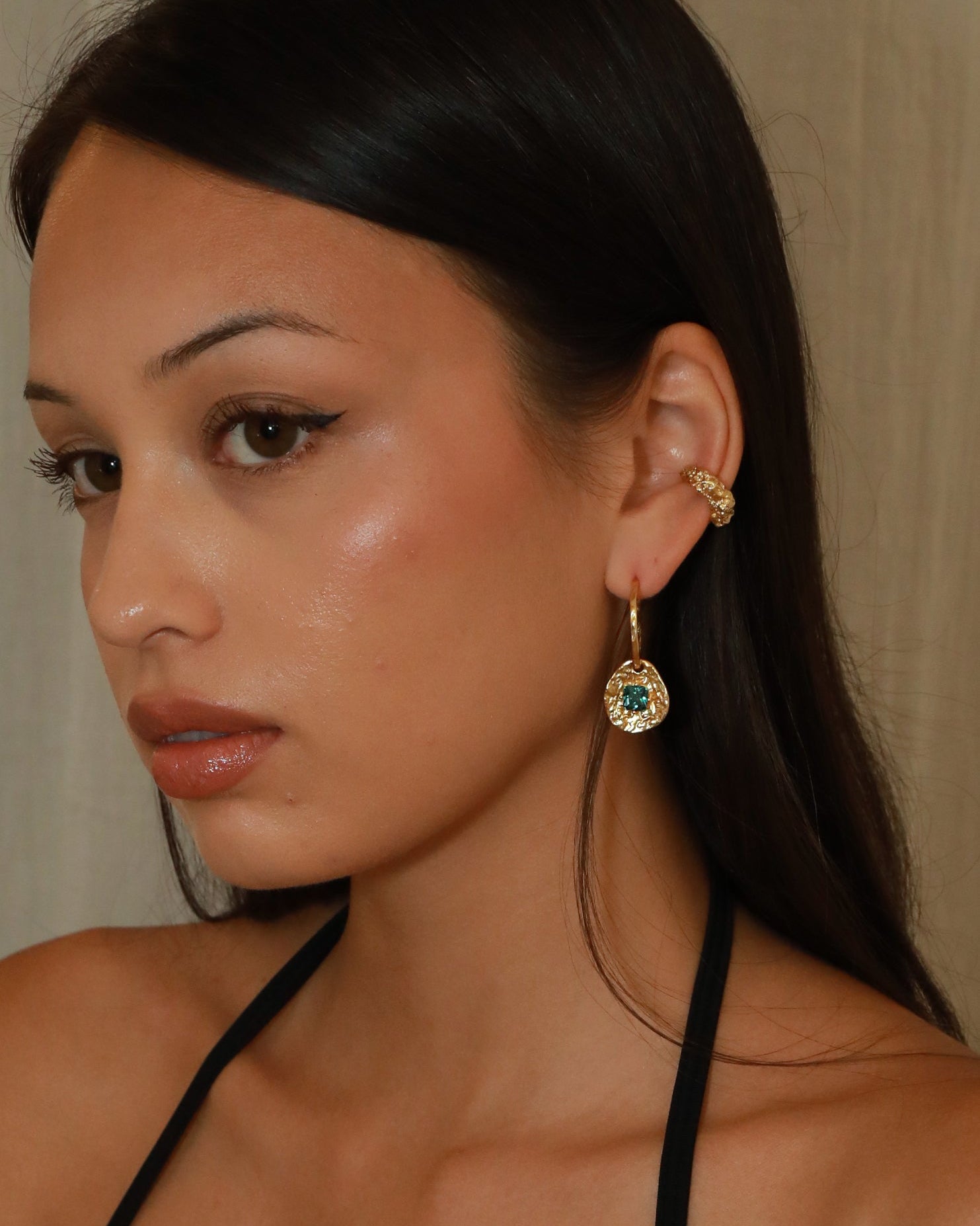 Cleo gold-plated brass coin drop earrings with hammered texture and square blue tourmaline CZ stones on model