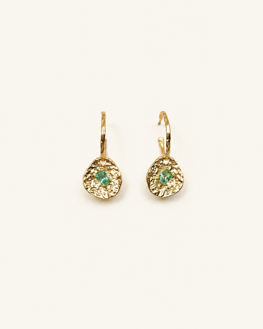 Gold coin drop earrings with hammered 18K gold-plated brass pendants and two round green beryl CZ stones on a white background.