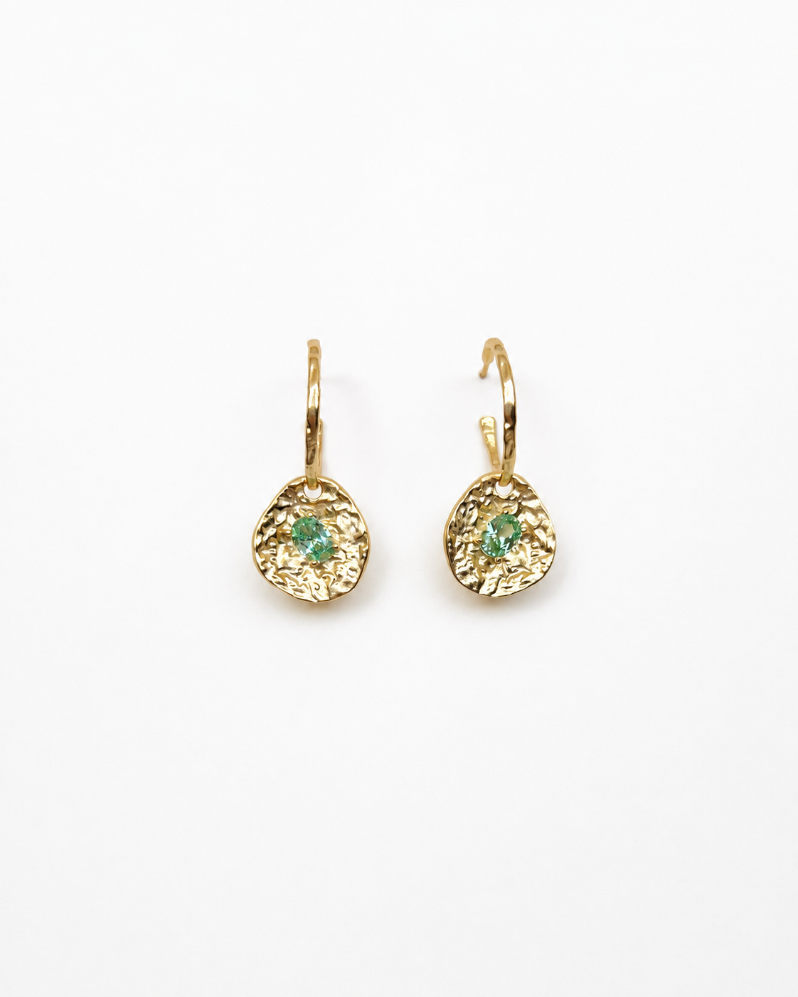 Gold coin drop earrings with hammered 18K gold-plated brass pendants and two round green beryl CZ stones on a white background.