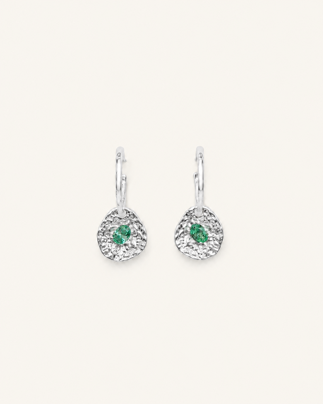Silver coin drop earrings with hammered silver-plated brass pendants and two round green beryl CZ stones on a white background.