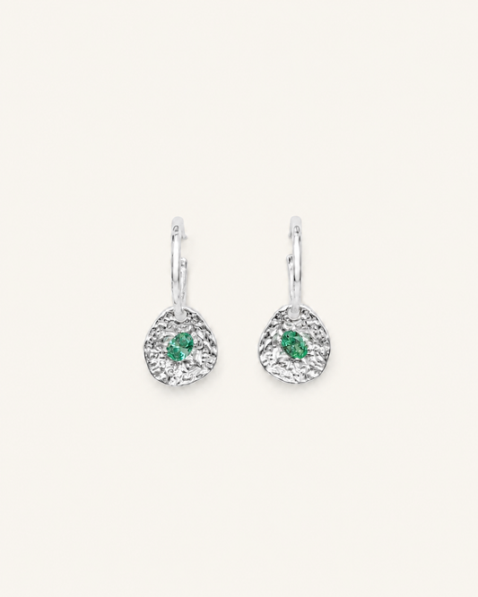 Silver coin drop earrings with hammered silver-plated brass pendants and two round green beryl CZ stones on a white background.