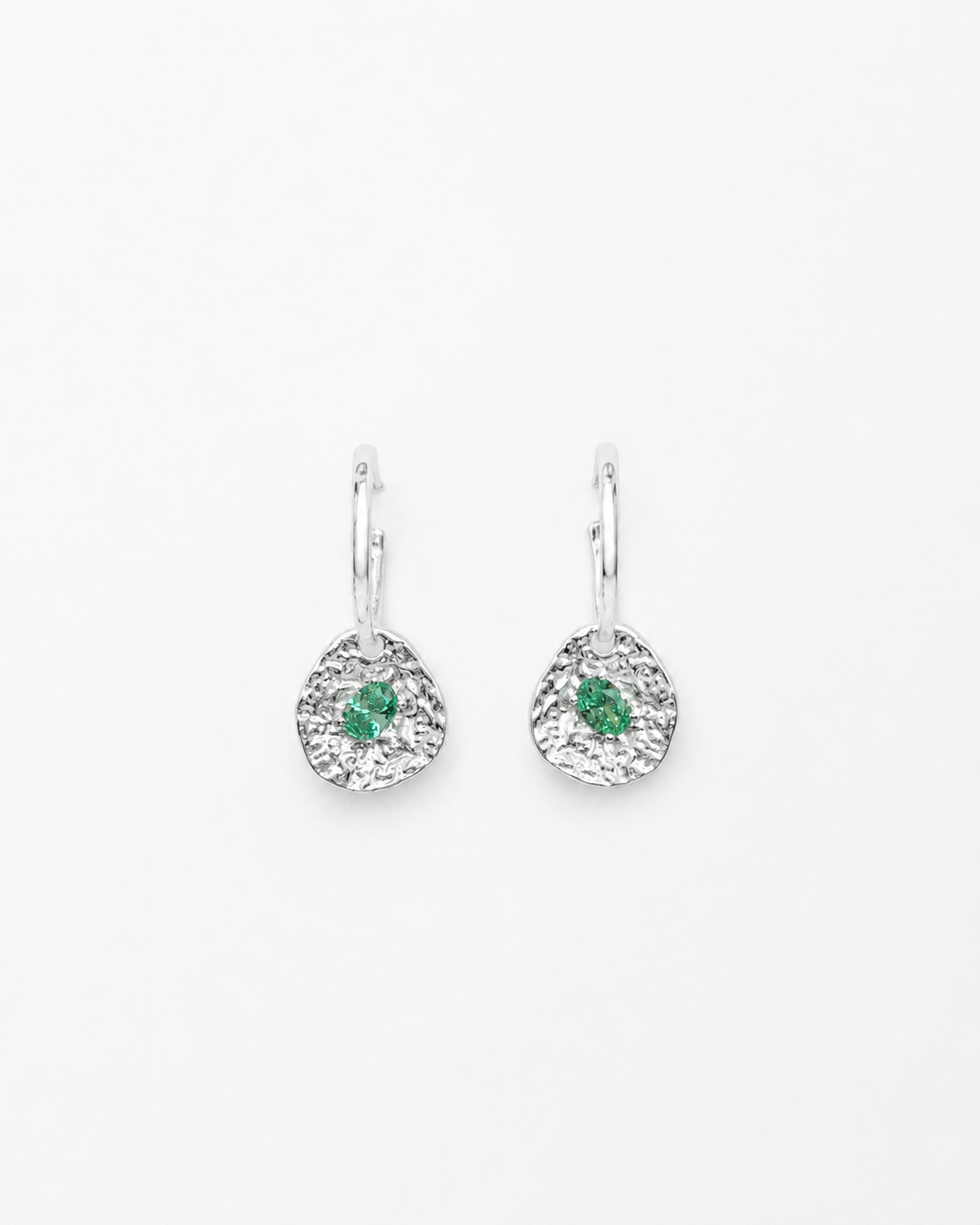 Silver coin drop earrings with hammered silver-plated brass pendants and two round green beryl CZ stones on a white background.