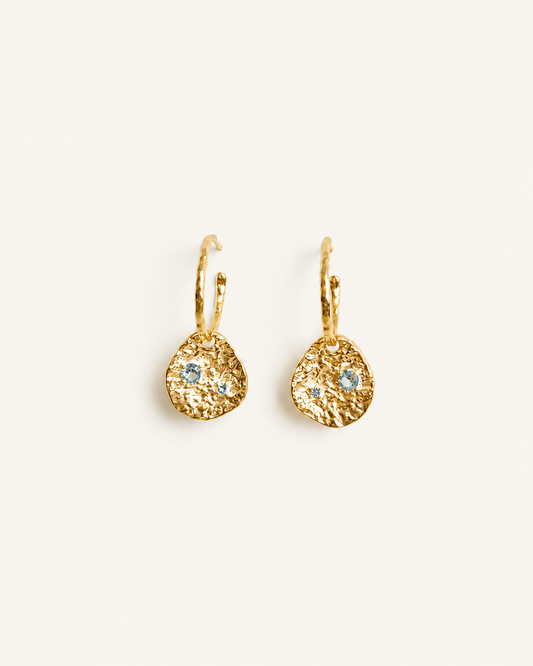 Gold coin drop earrings with hammered 18K gold-plated brass pendants and two round lab-grown aquamarine-blue spinel stones 