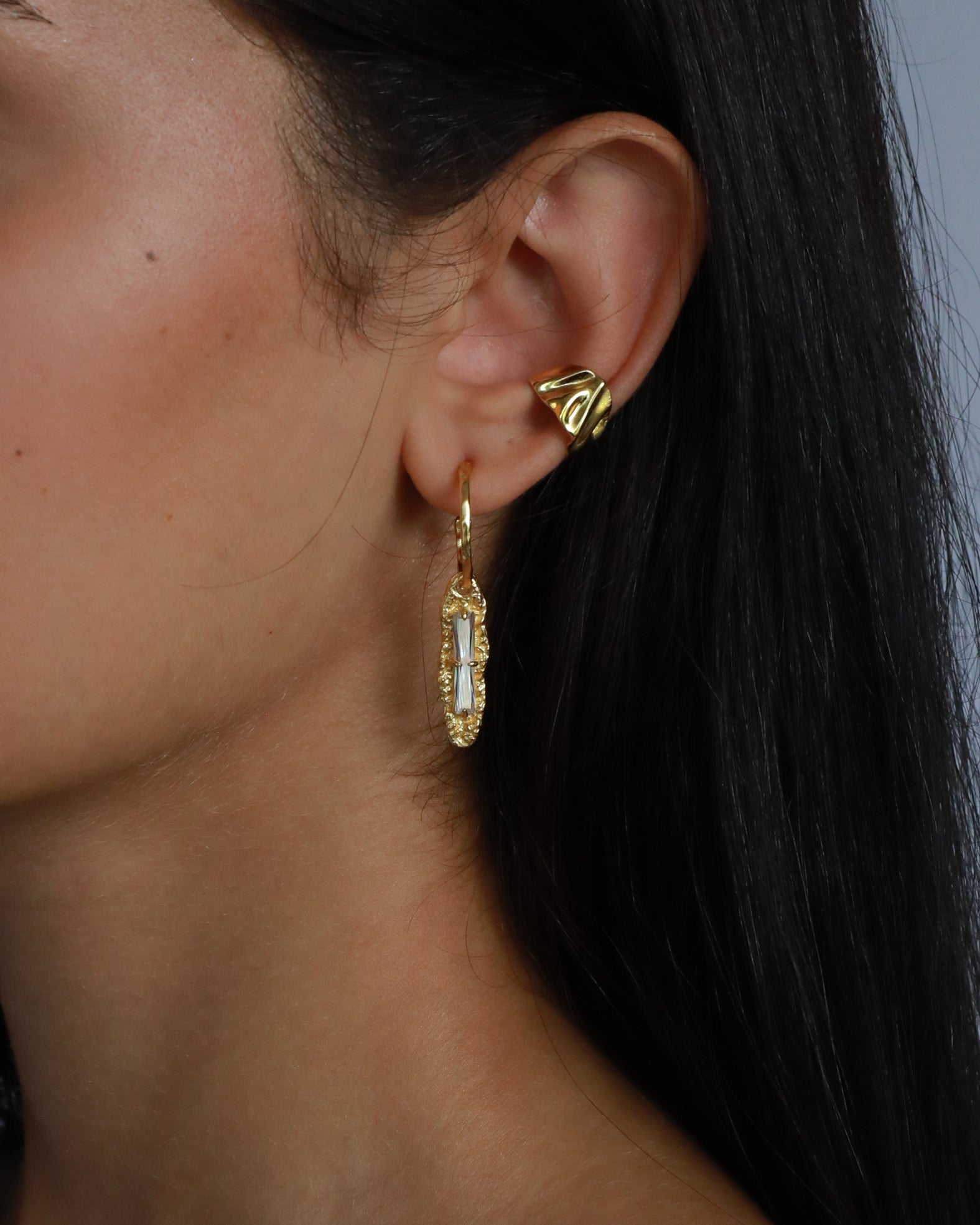 Close-up of sculpted 18K gold ear cuff with textured finish, designed for non-pierced ears