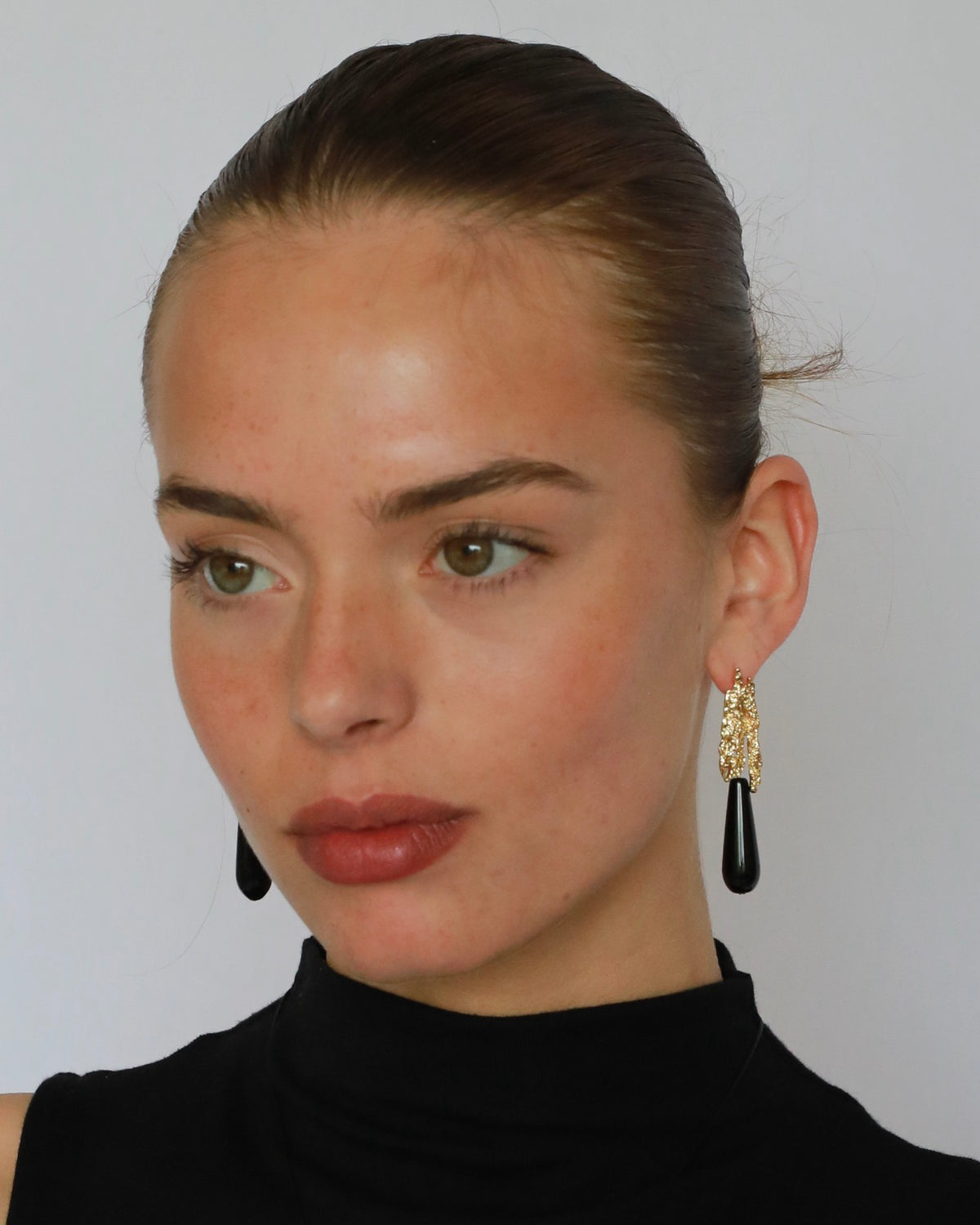 Natural black onyx teardrop earrings with textured gold-plated brass