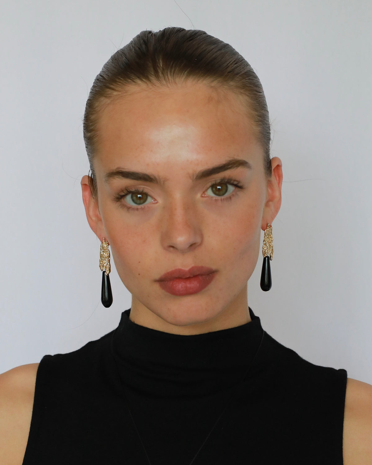 Natural black onyx teardrop earrings with textured gold-plated brass model