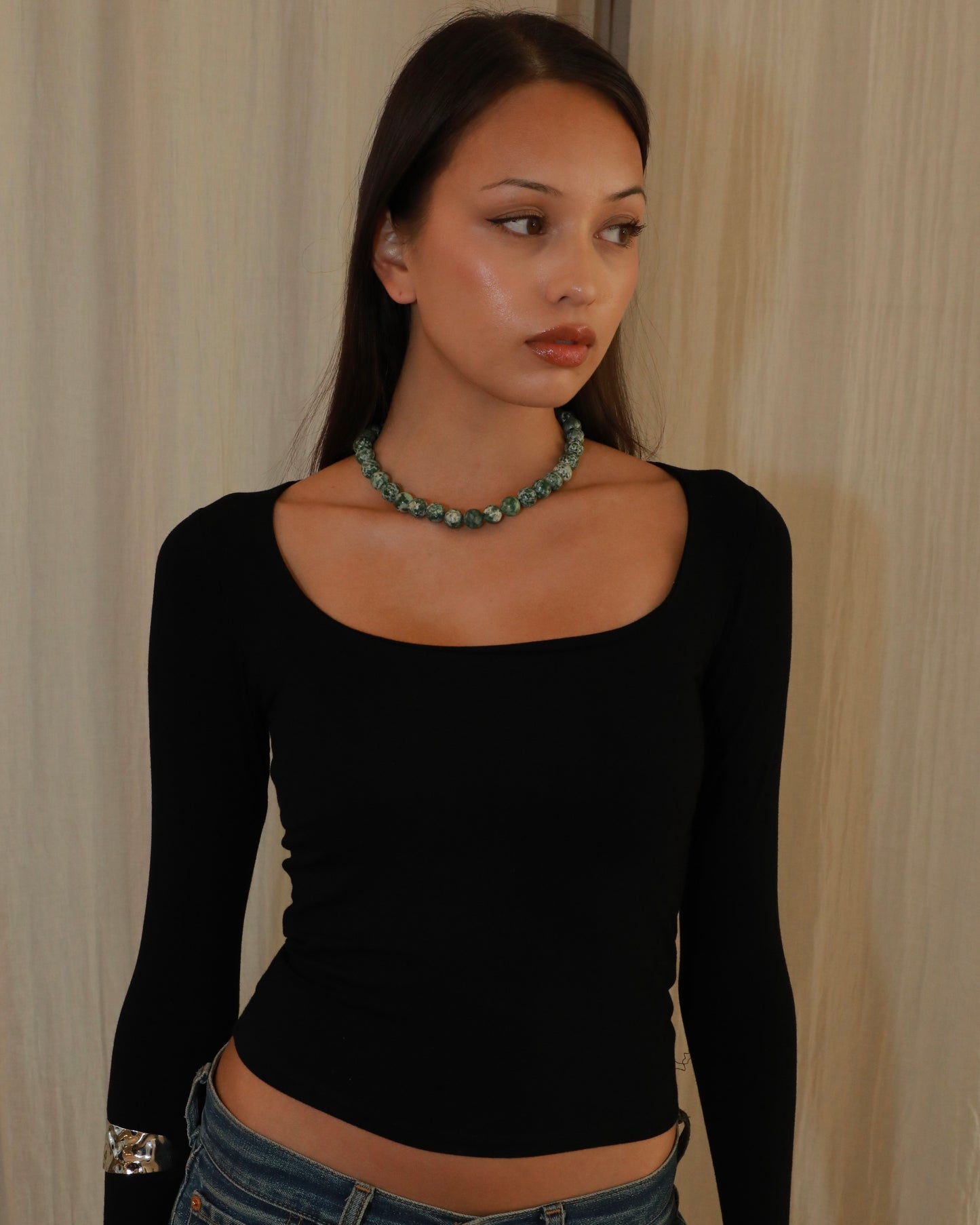 Natural green spot stone beaded necklace with green and white patterned beads model close up 