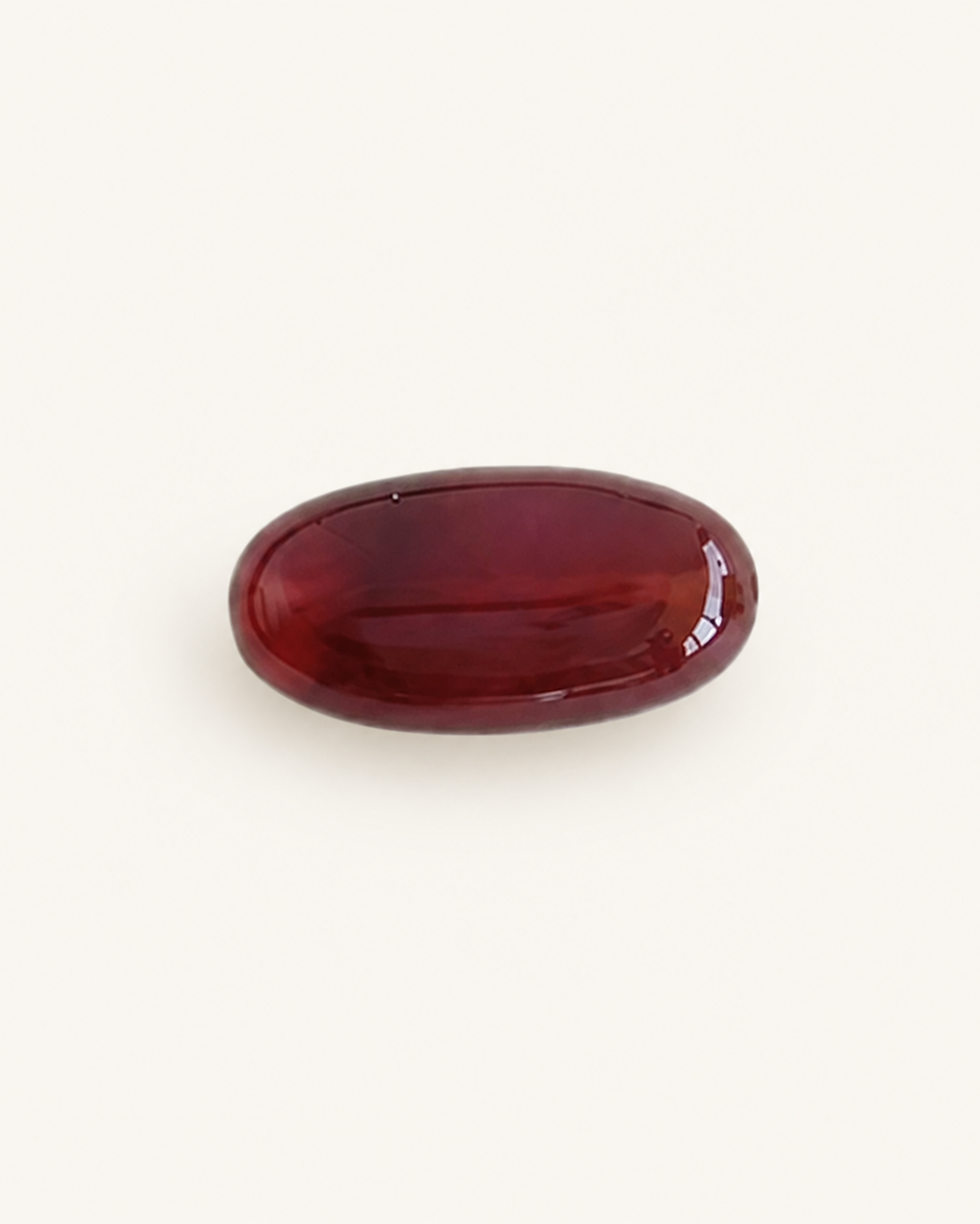 Deep red agate cabochon with a high polished dome catching light