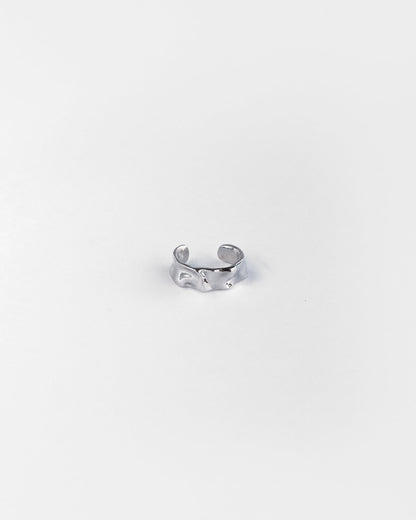 Close-up of sculpted silver ear cuff with textured finish, designed for non-pierced ears